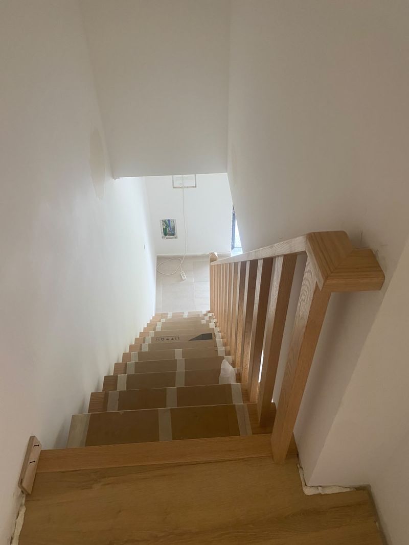 A mesma escada vista a partir do piso superior, com o corrimão à direita.